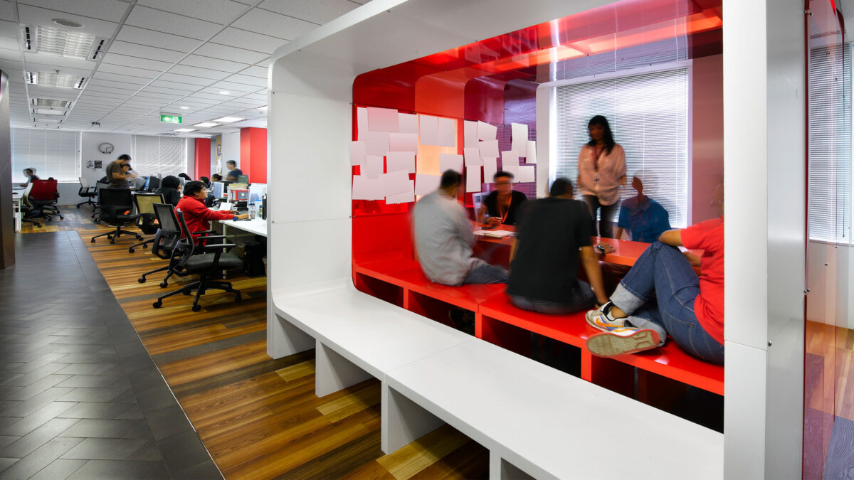 people collaborating in meeting room cubicle and people working in open plan area