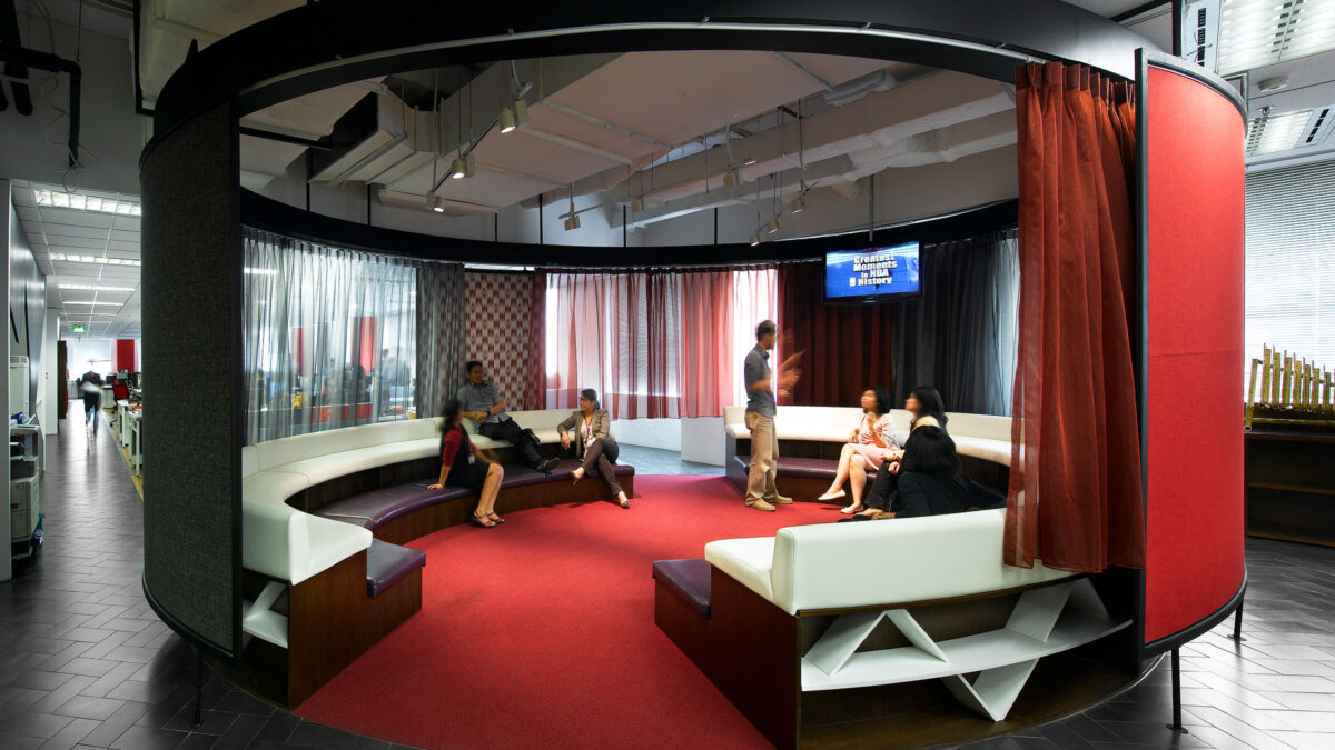 people sitting on tiered seats in theatre while man gives presentation