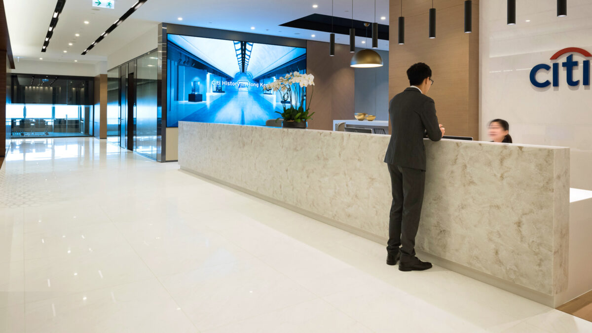 reception area with man and woman talking with logo in background