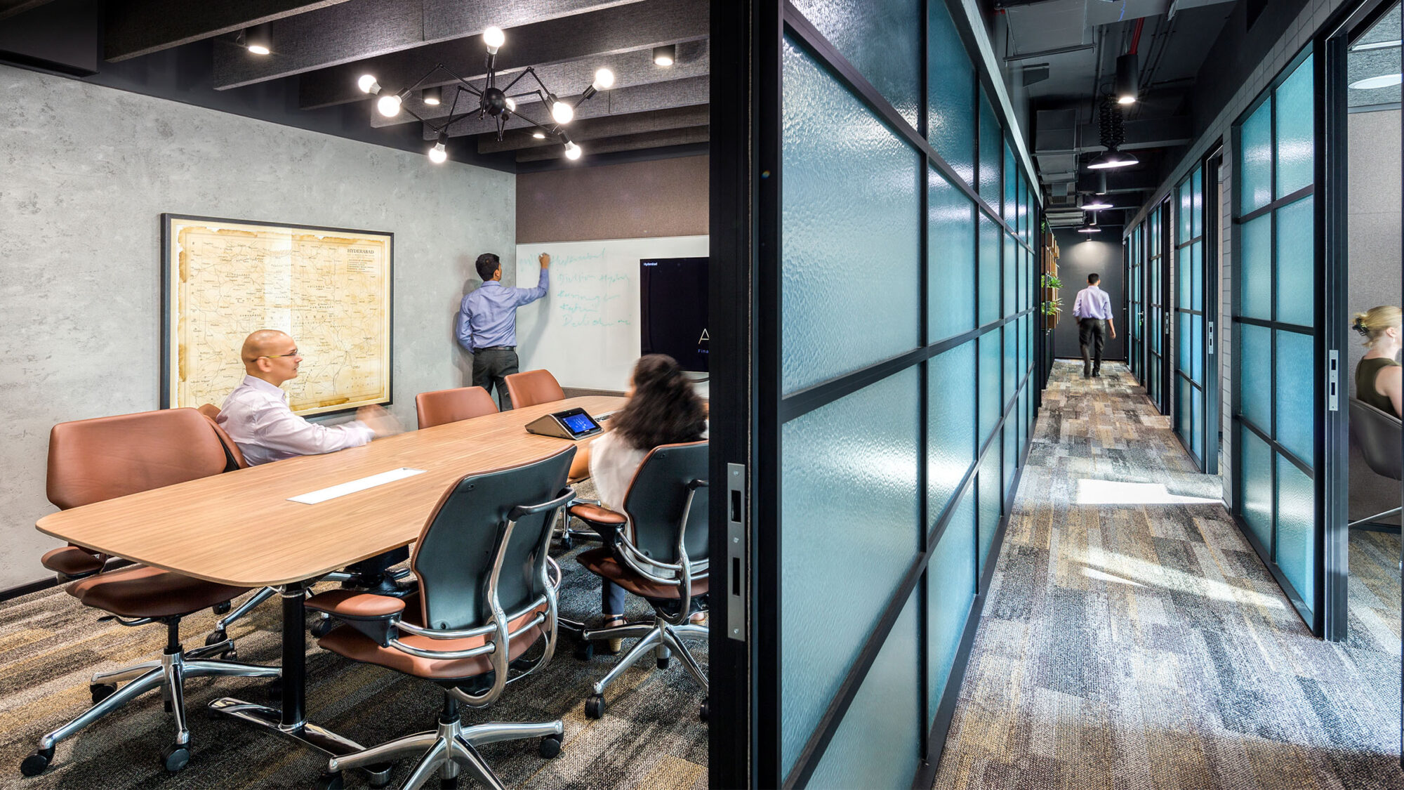 People in meeting room and view of corridor