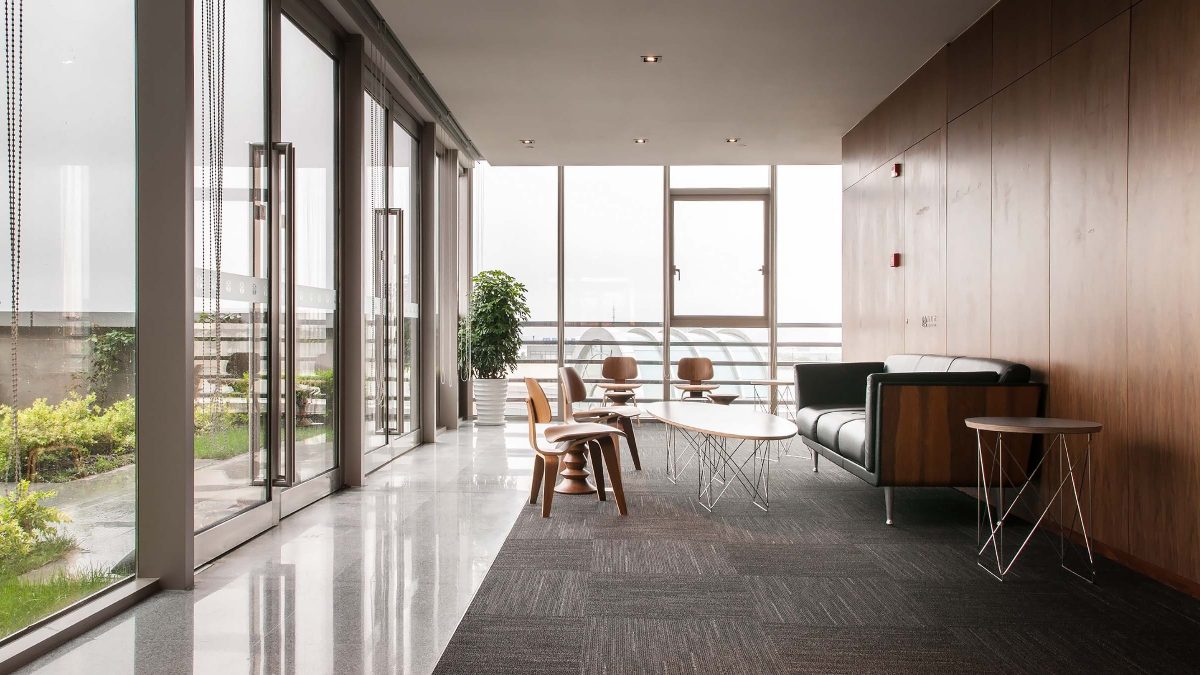 Workplace corridor featuring natural wood and supportive furniture.