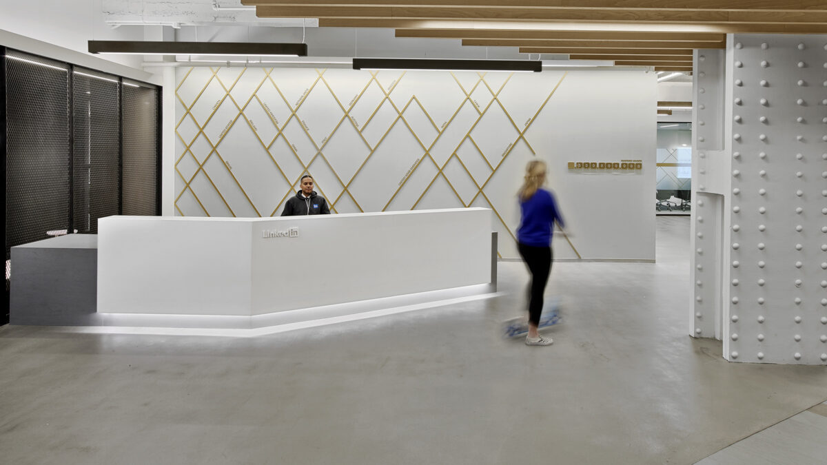 Man at reception desk and woman walking by