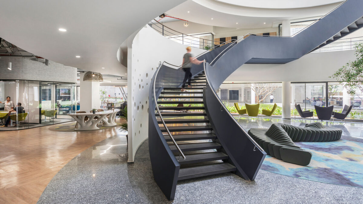 Woman walking up staircase and desks