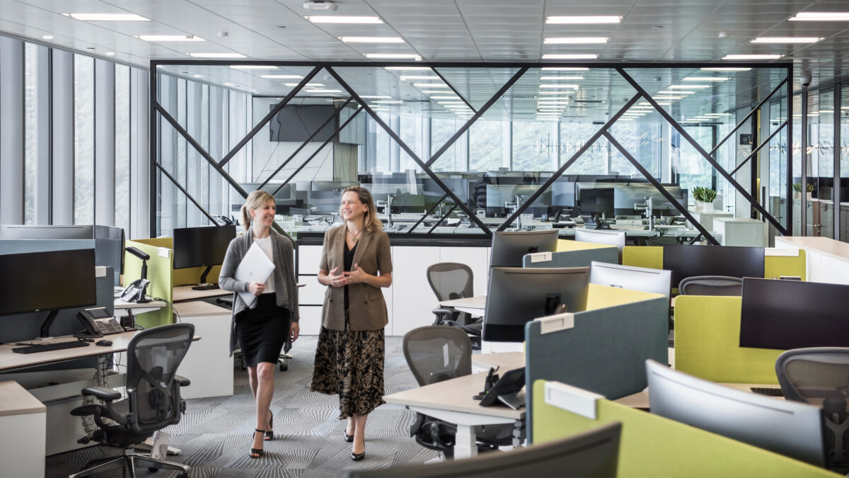 women talking walking through office