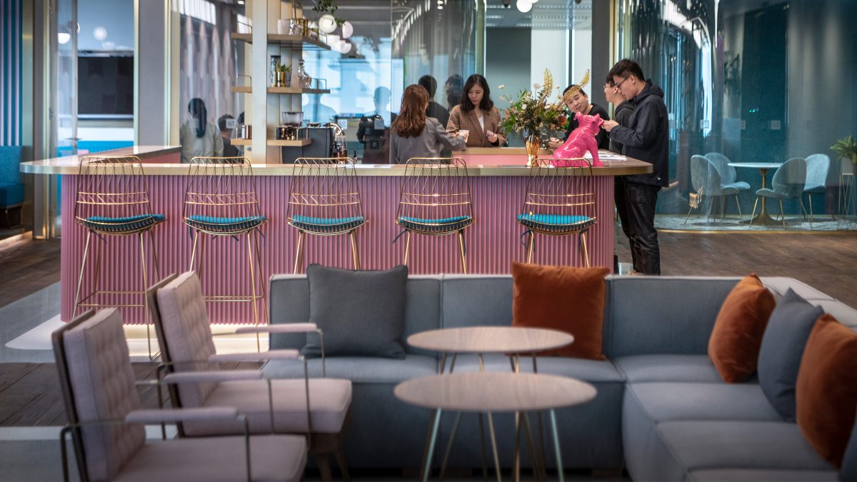 man at reception desk and view of lounge seating area