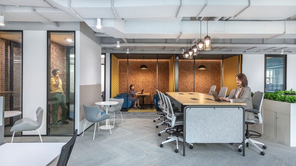 woman at table, man in meeting room and woman in booth