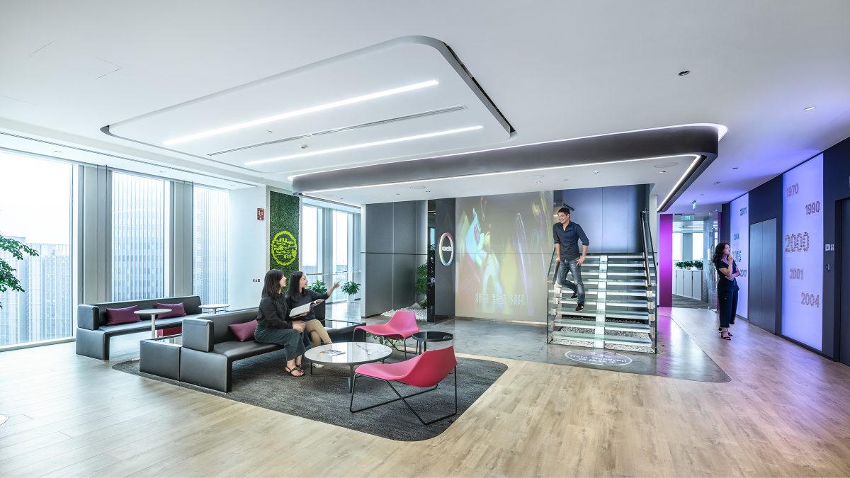 woman giving presentation to colleagues who sit in lounge