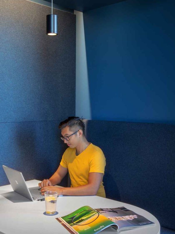 man sitting in blue work booth