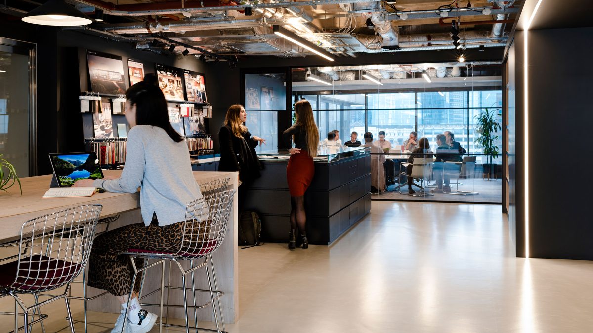 people talking in lobby, woman working at counter and people in conference room