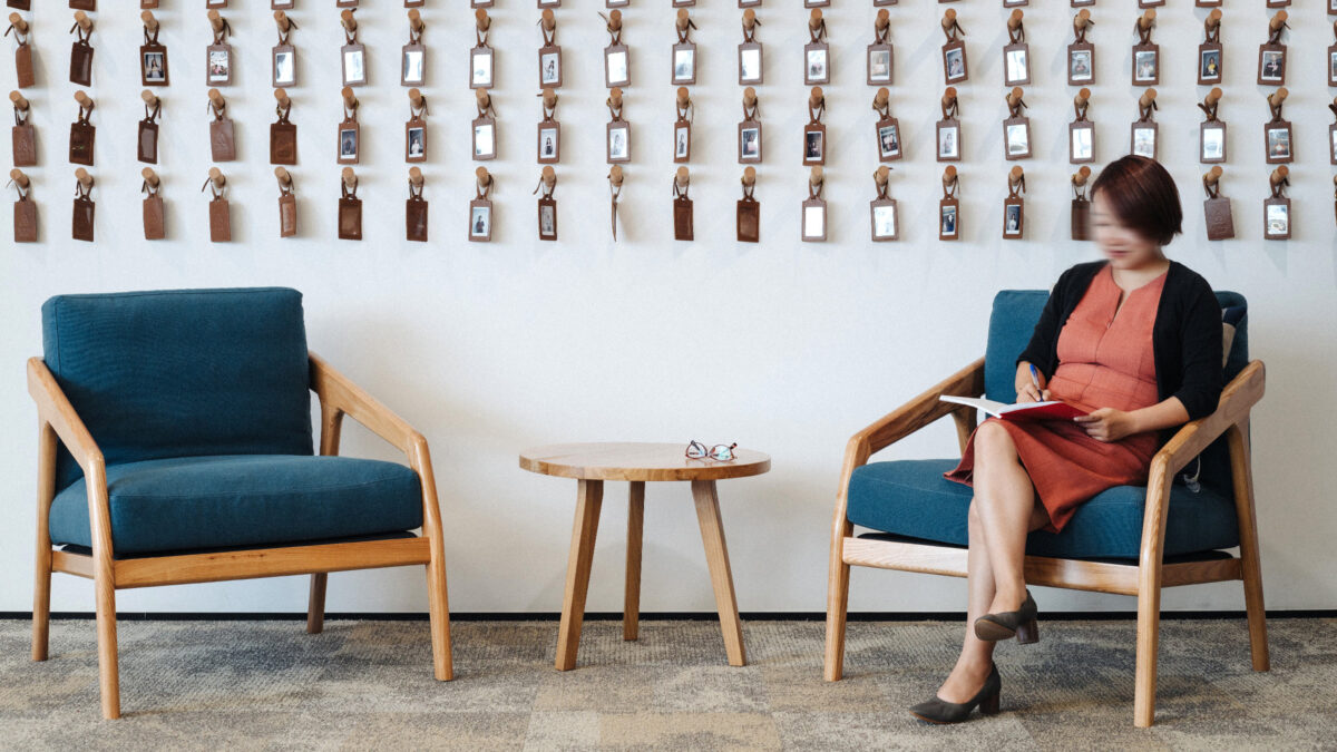 woman sitting in front of brand artwork