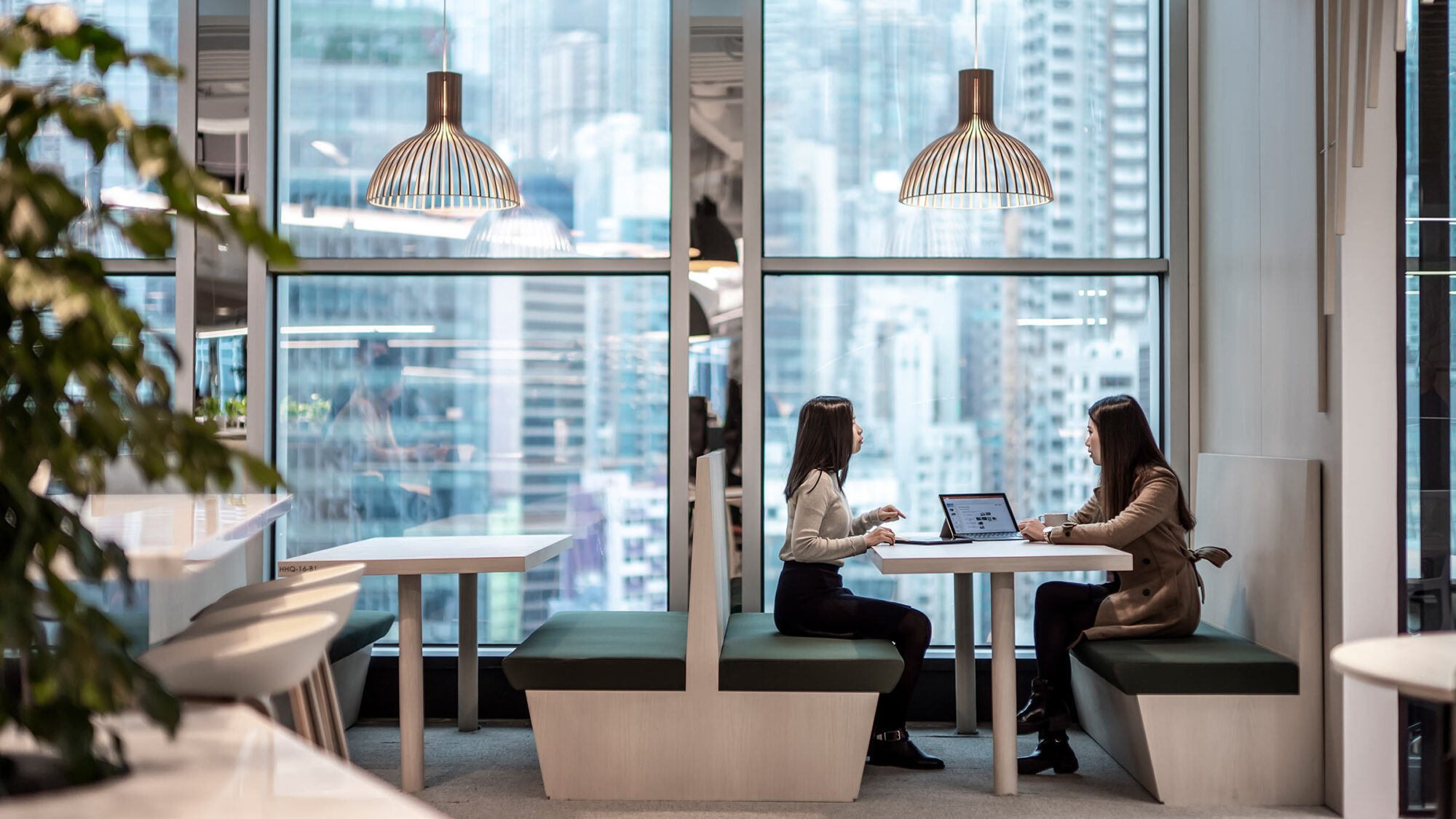 women talking in booth next to window