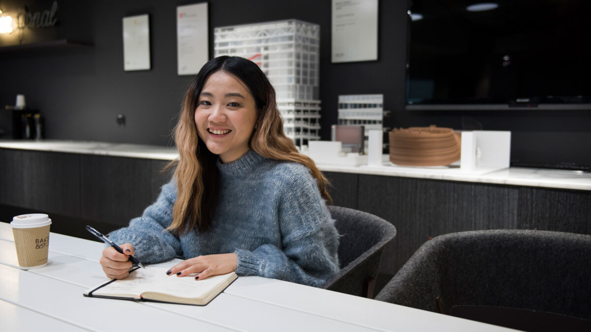 smiling woman in front of architectural models