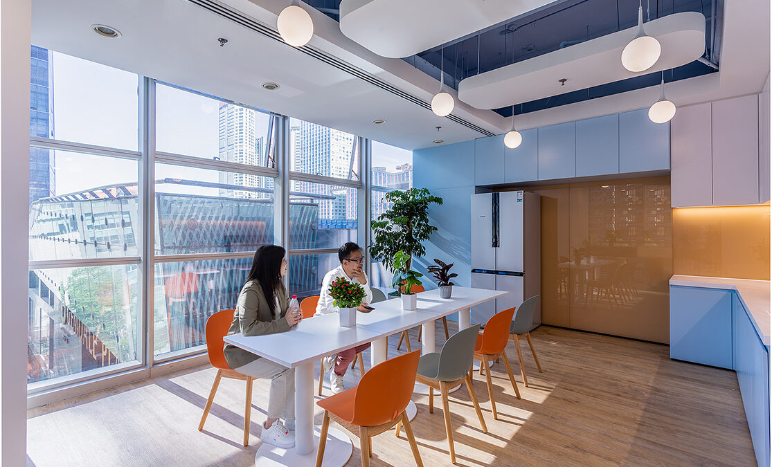 Colleagues sitting at table in kitchen area