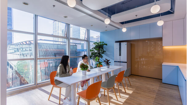 Colleagues sitting at table in kitchen area