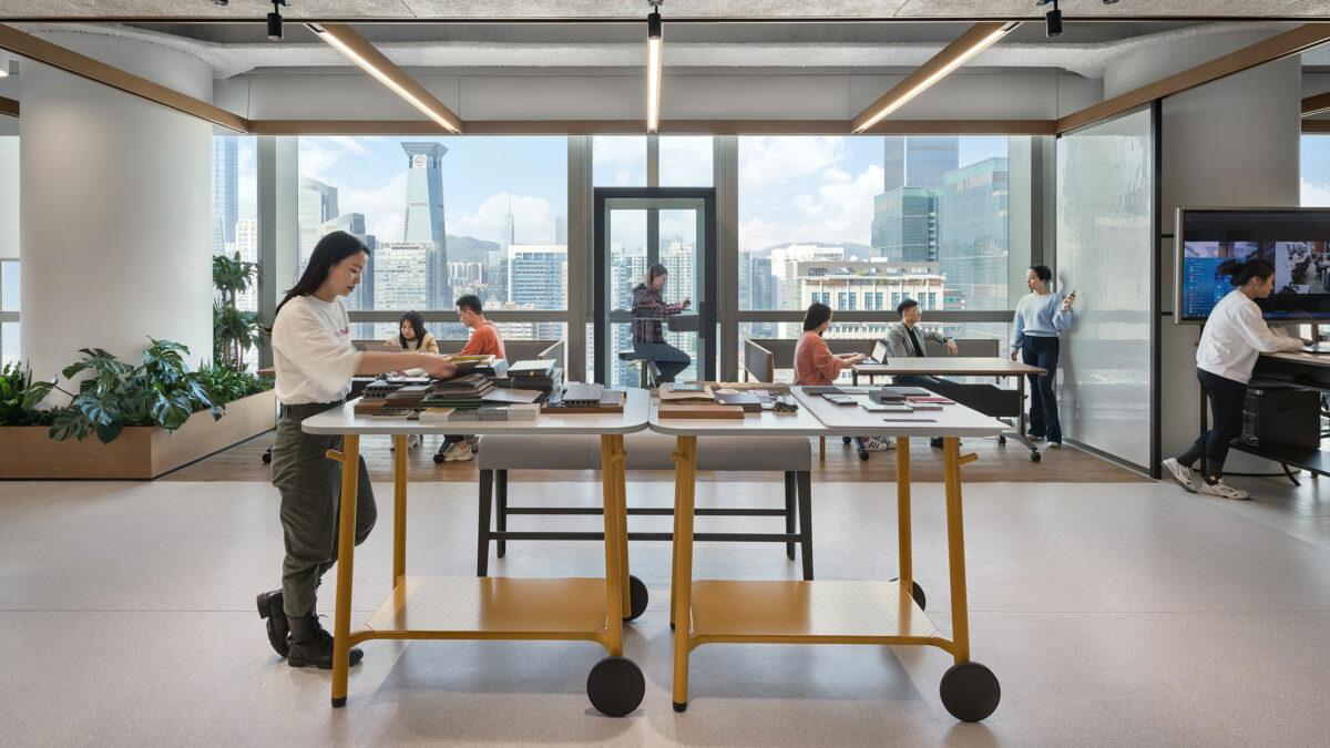 person walking at work bench in open office