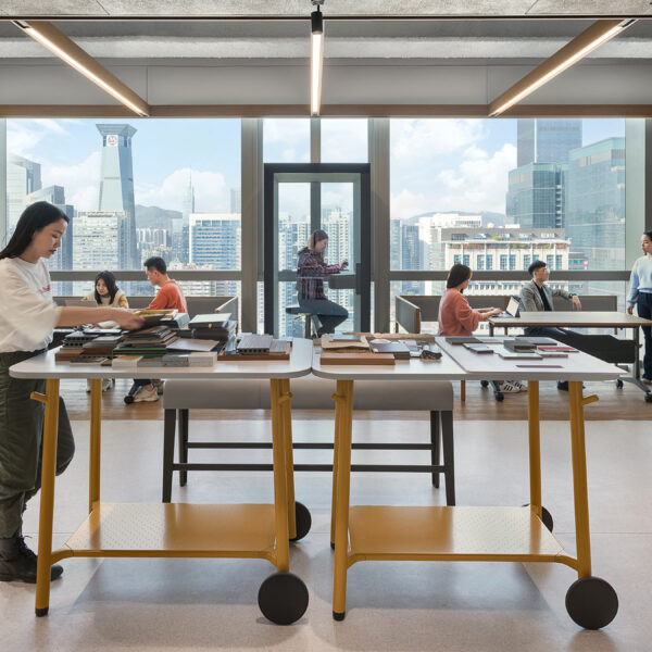 person walking at work bench in open office