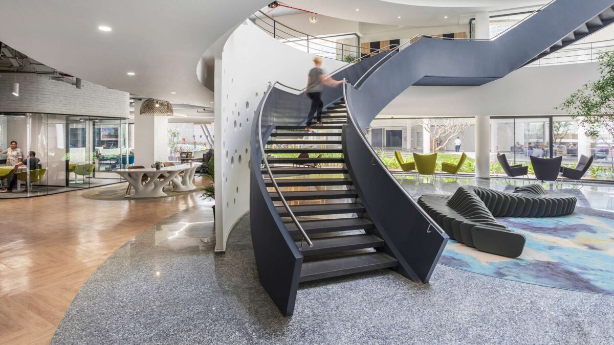 Woman walking up staircase and desks