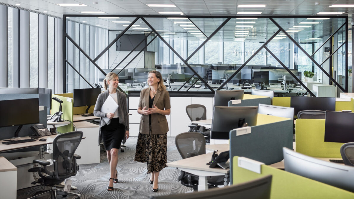 women talking walking through office