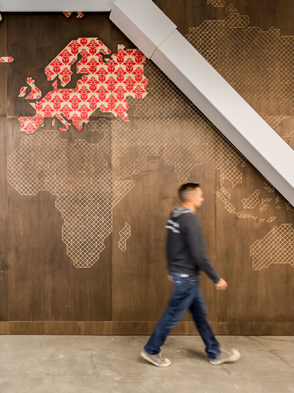 man walking past graphic map on wall