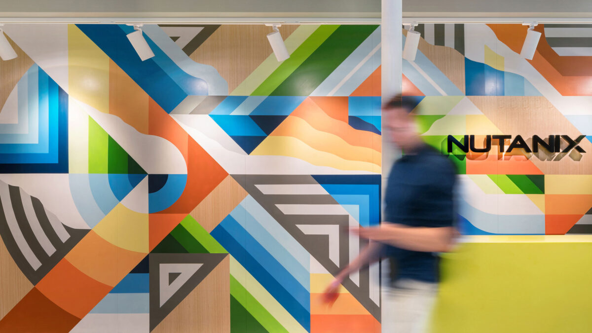 man walking in front of branded artwork wall