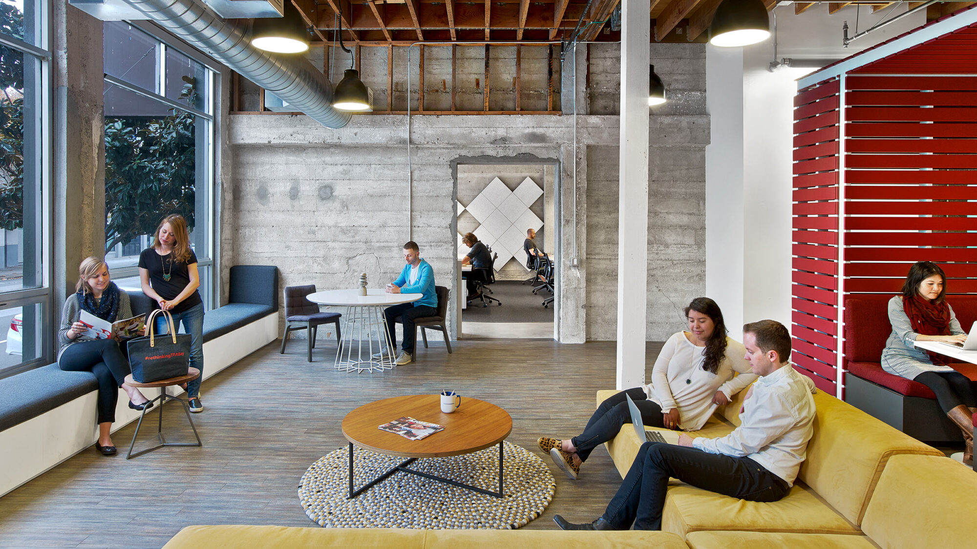 people collaborating in lounge space near desks