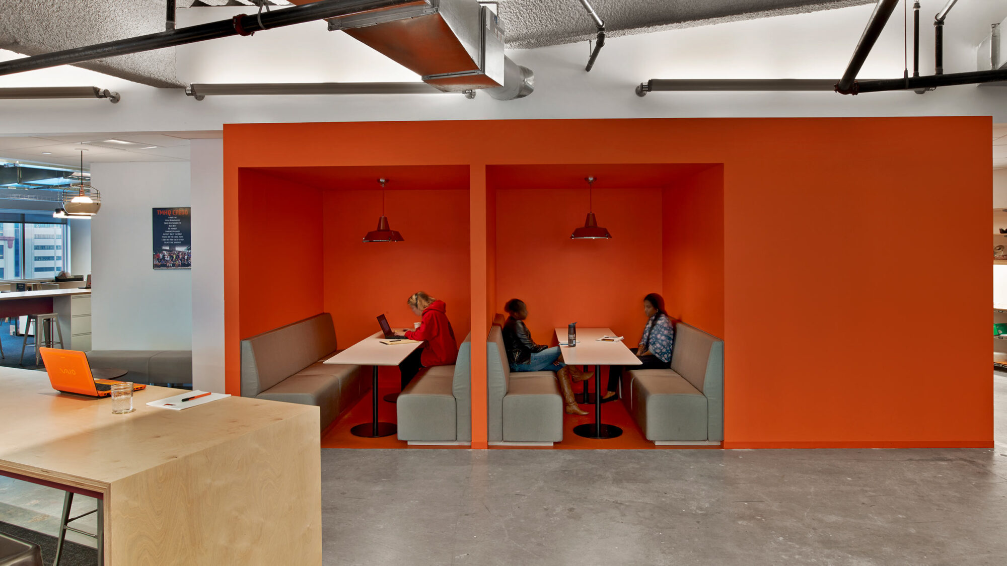 people working in orange booths