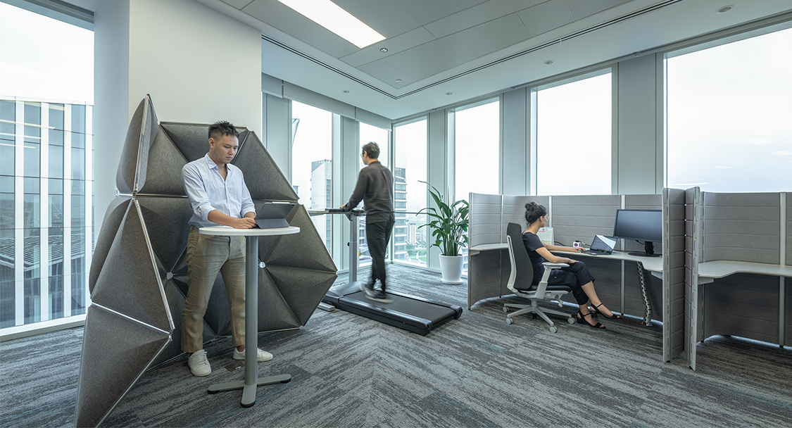 man working in standing booth, woman working in booth and man on treadmill