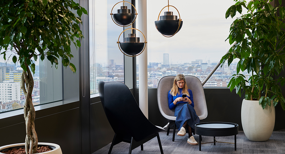 woman sitting on her phone in casual seating area