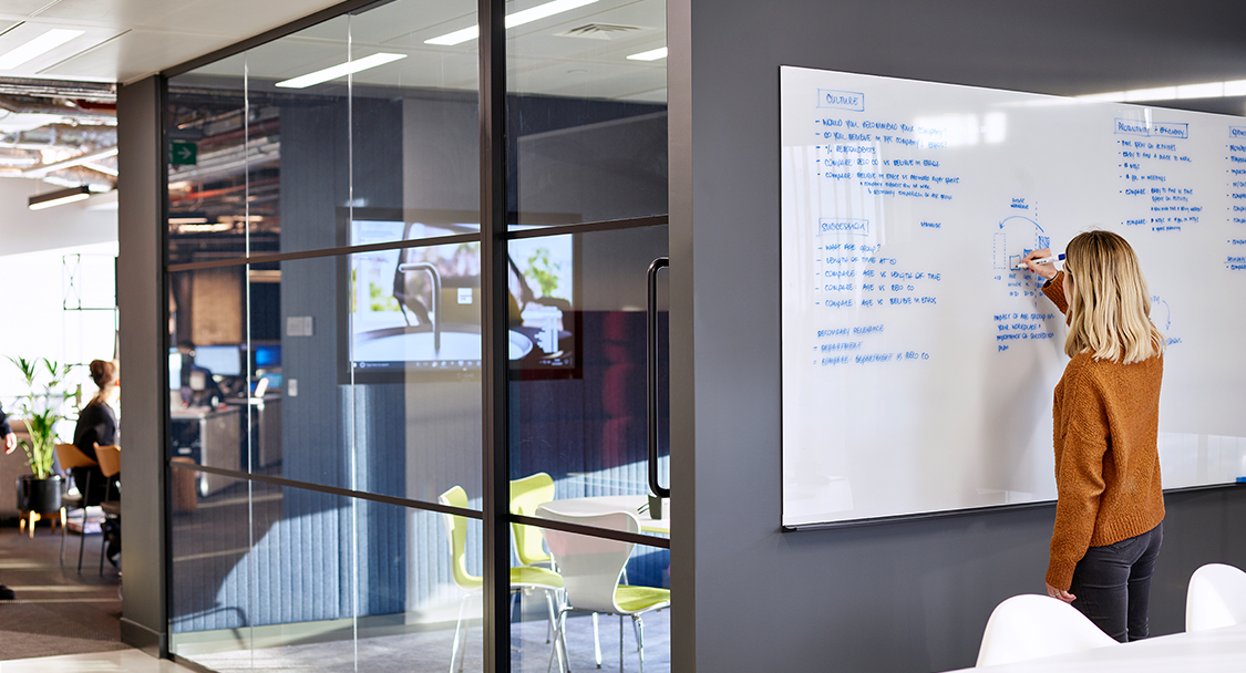 woman writing on whiteboard and meeting room