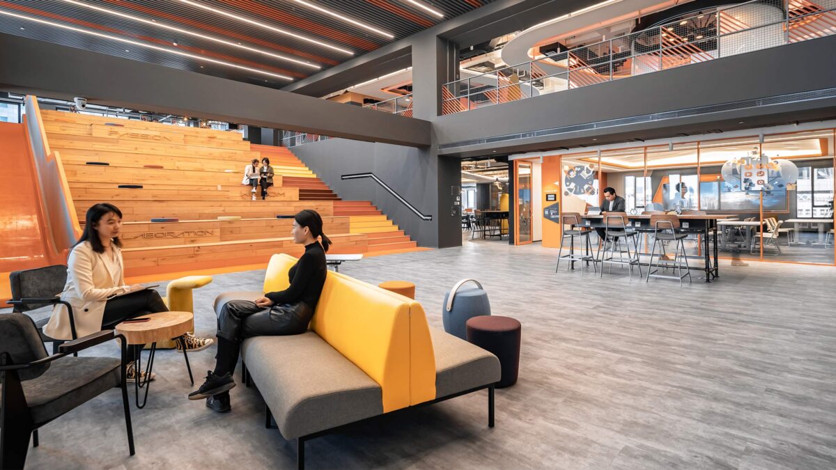 people collaborating on tiered stairs, casual space and man on desk