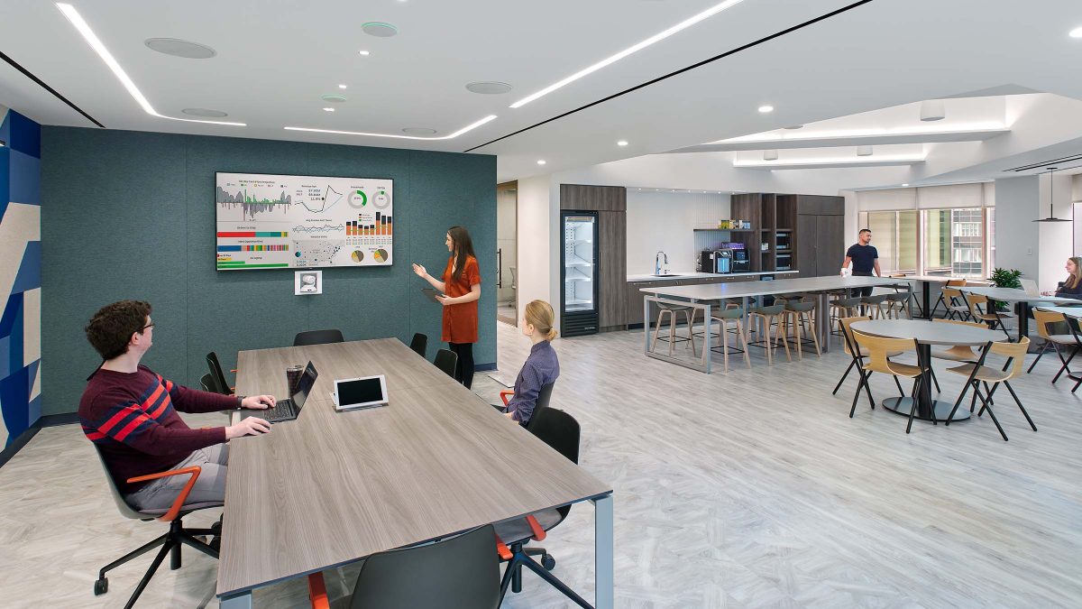 Collaborative workspace design featuring a large table and technology to support the employee experience.