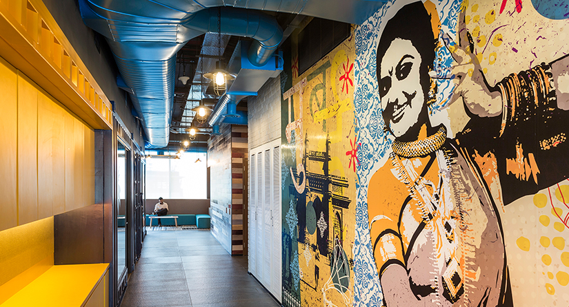 mural and man sitting at end of corridor