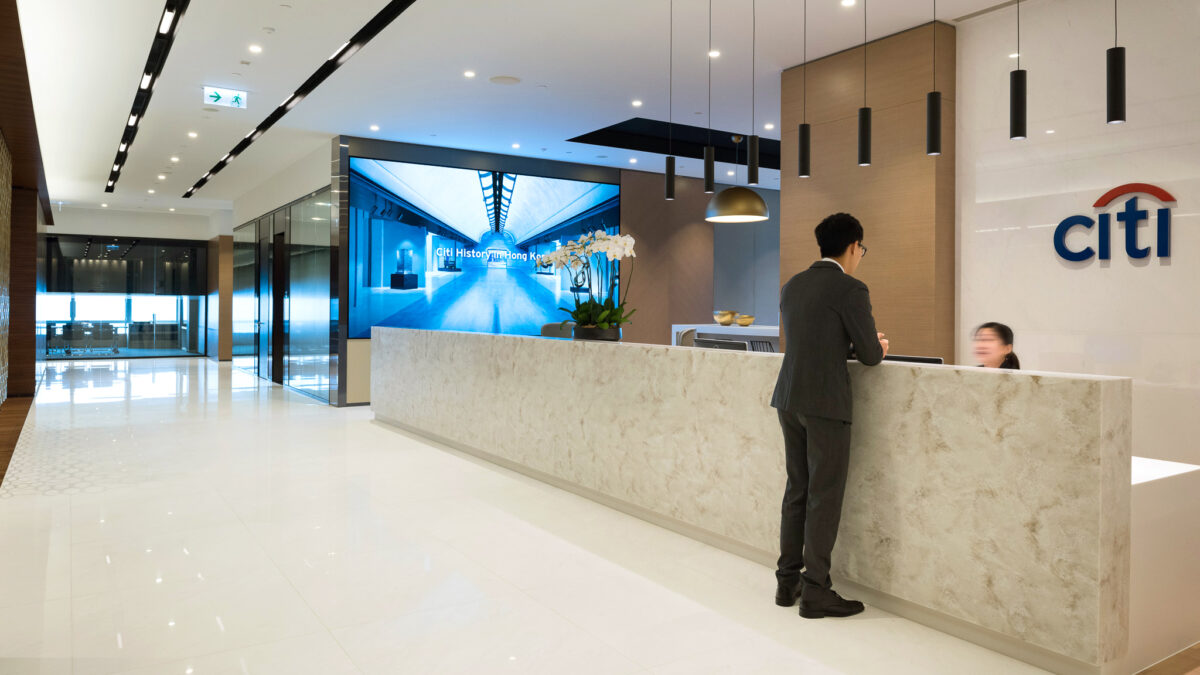 reception area with man and woman talking with logo in background