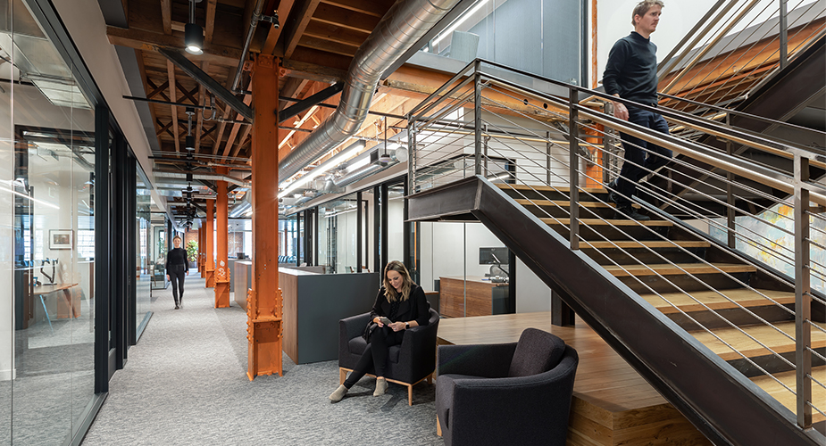 man walking down staircase and woman sitting in chair