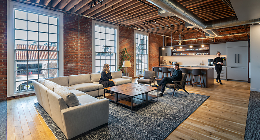 people in lounge and woman in kitchen