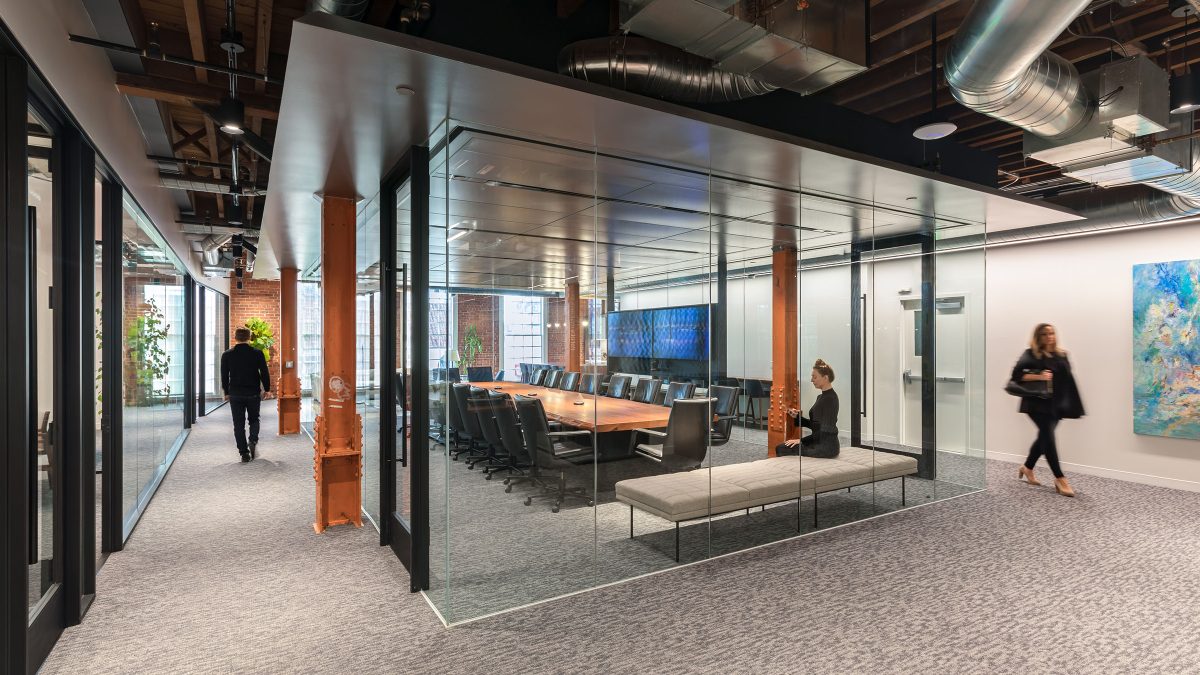 woman sitting in meeting room and people walking around