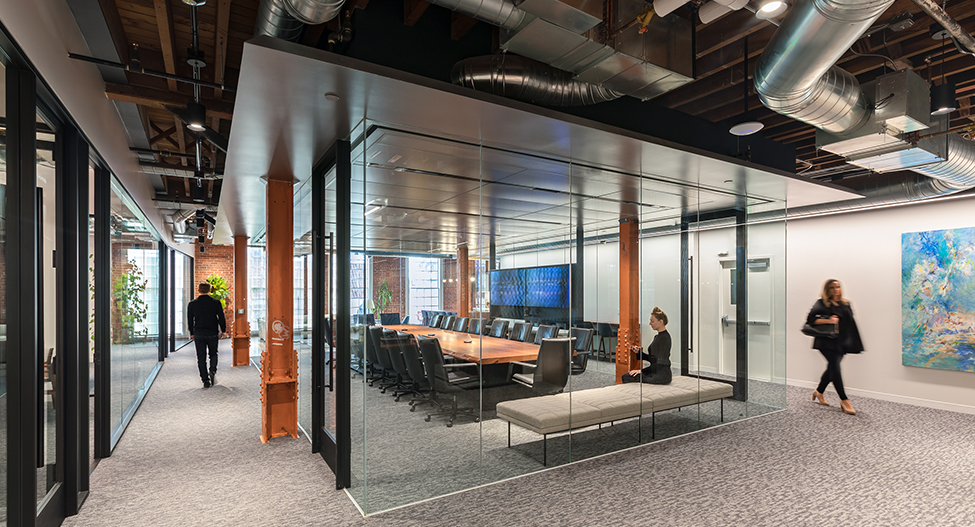 woman sitting in meeting room and people walking around