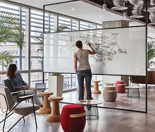 women collaborating and woman writing on whiteboard