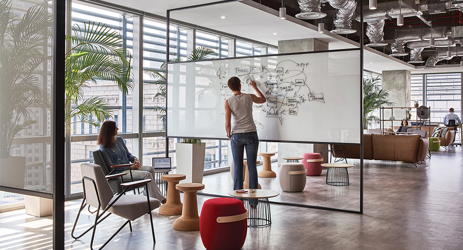 women collaborating and woman writing on whiteboard