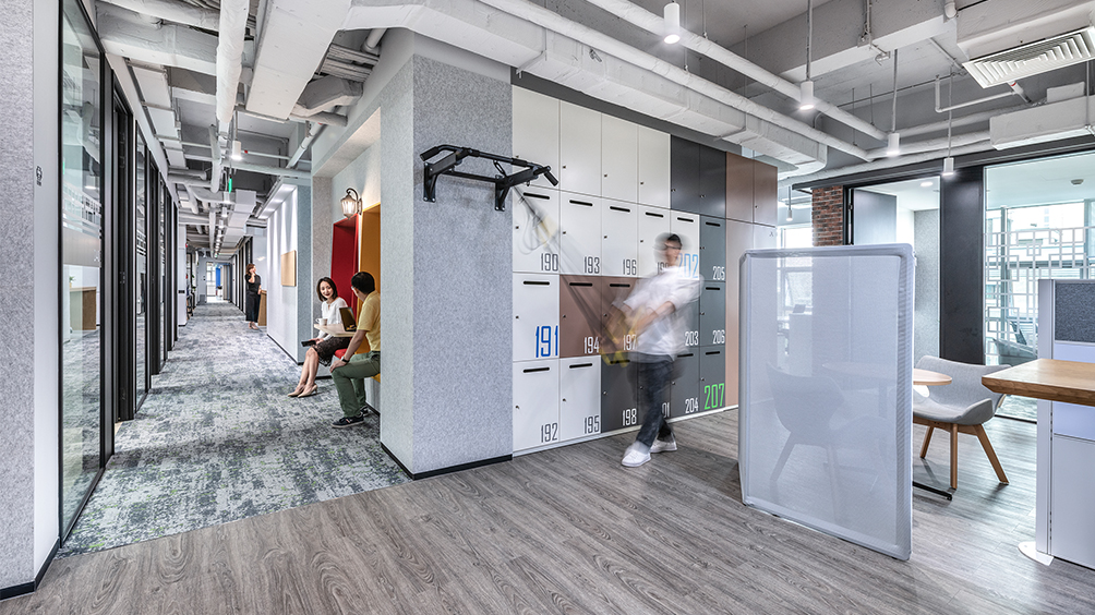 man walking down corridor and people collaborating in booths