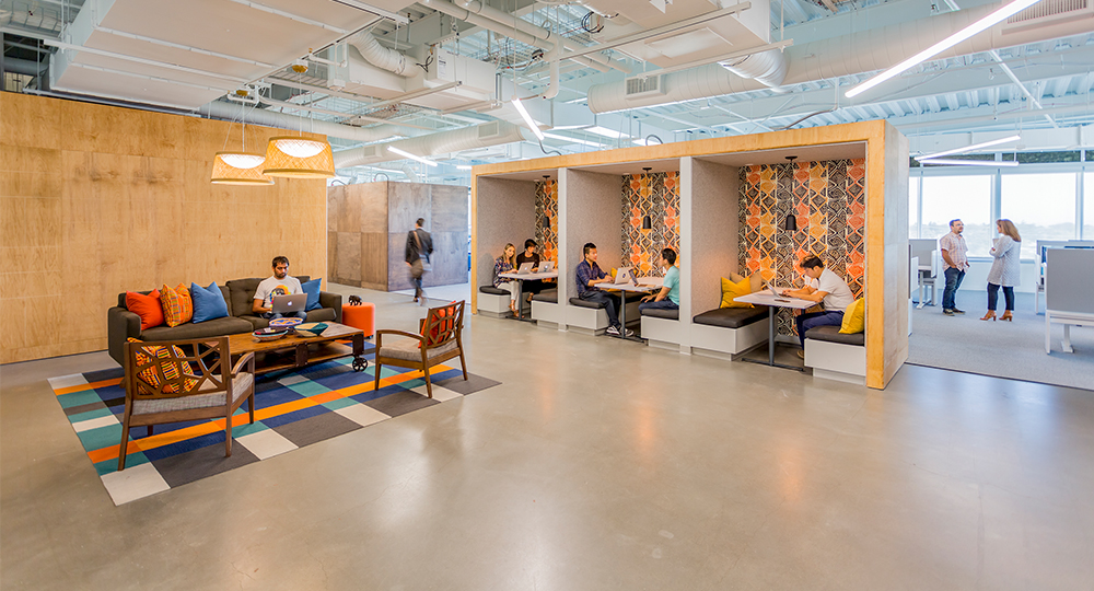 people collaborating in booths and man working in open space