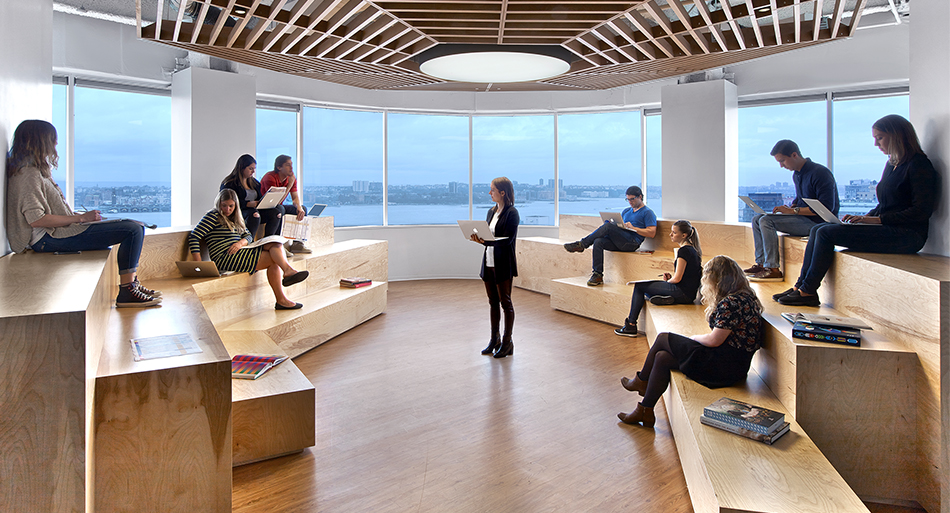 people sitting on tiered seats while woman gives presentation