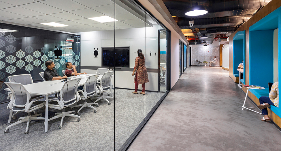 woman presenting and people in booths outside meeting room