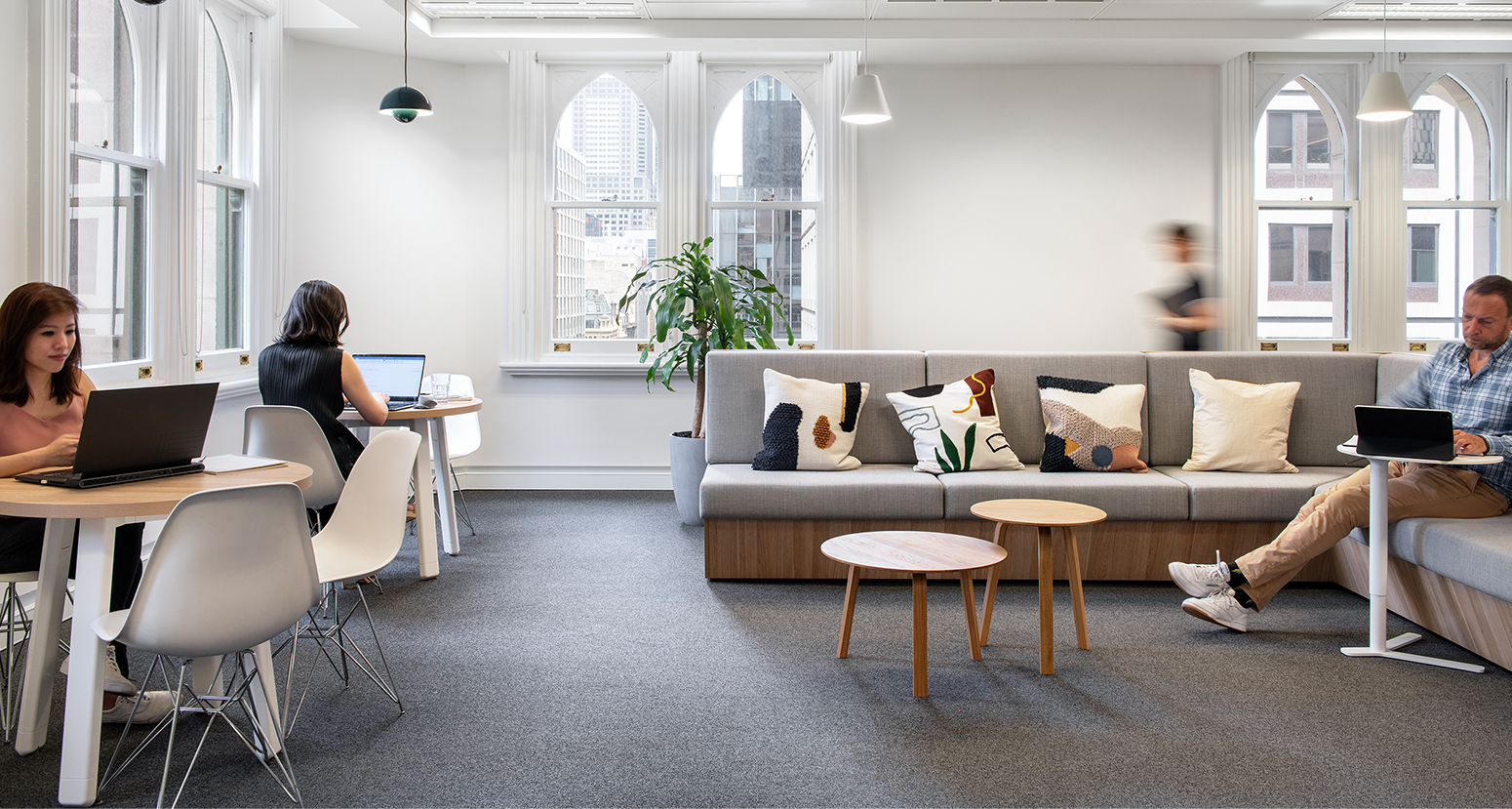 women working at desks and man in casual seating area