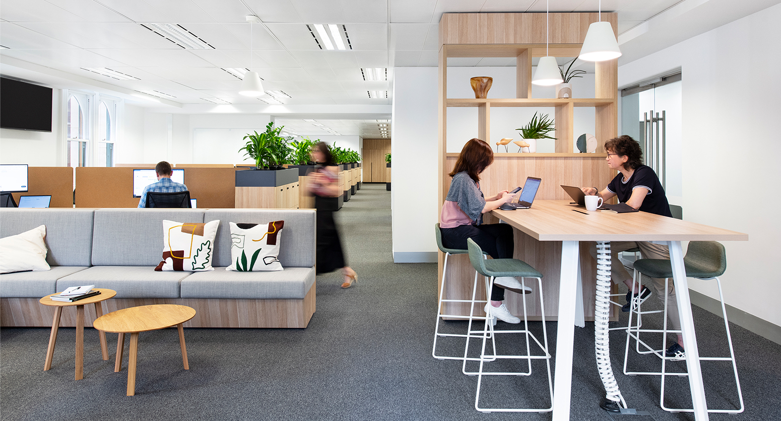 women working at table, view of desks and casual seating