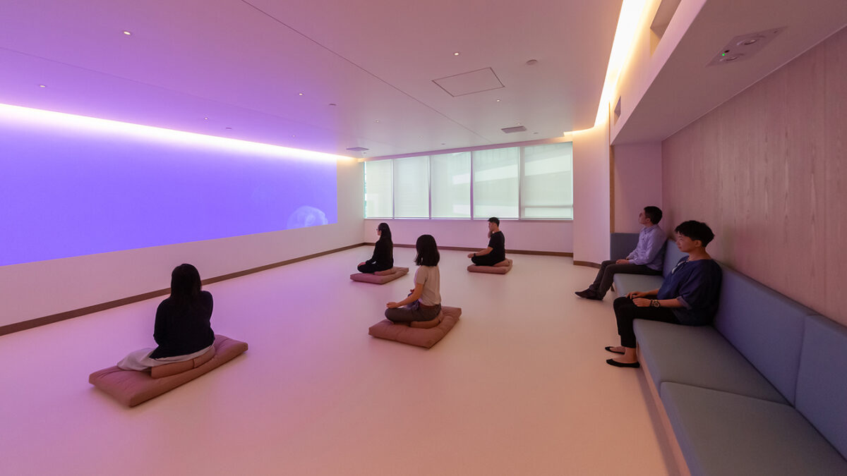 people meditating and others sitting and observing