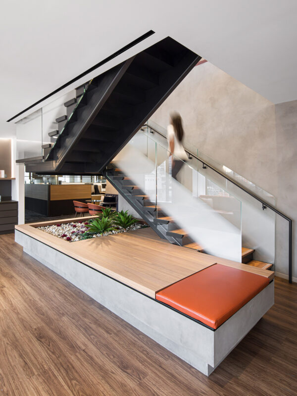 woman walking up staircase and view of open plan office with partitions