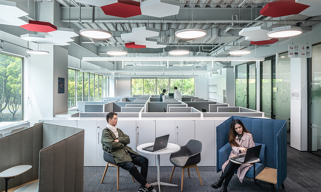 Man and woman collaborating in open-plan area with partitions