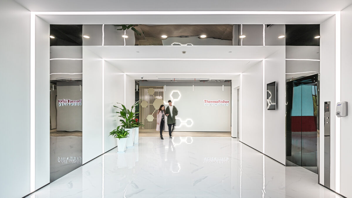 people walking in corridor near lifts and view of logo