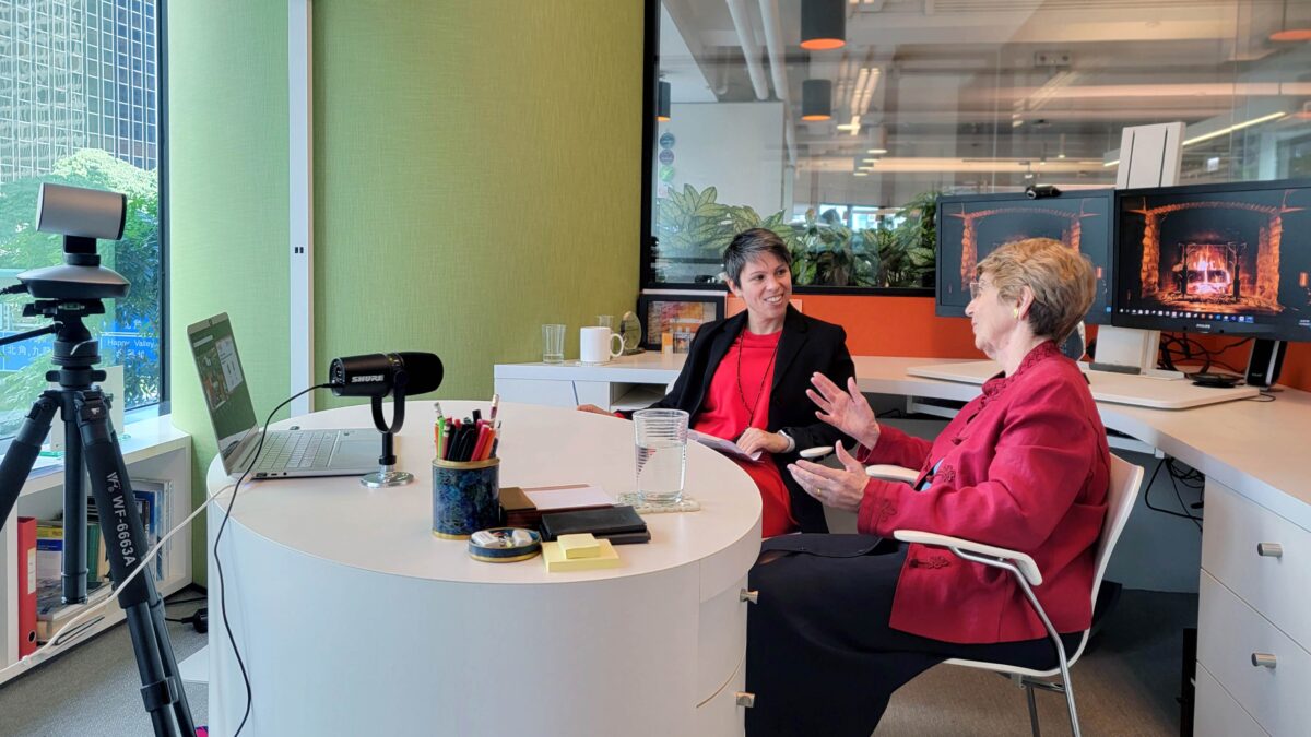 Two people talking in green office